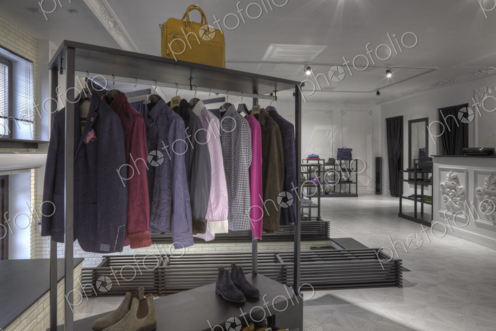 Suits and shoes on rack in clothing store for men