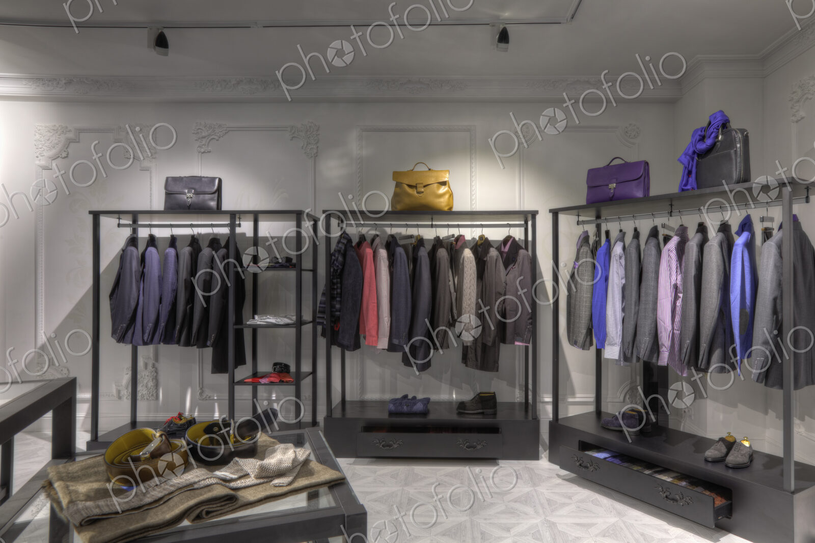 Suits and shoes on racks in clothing store for men