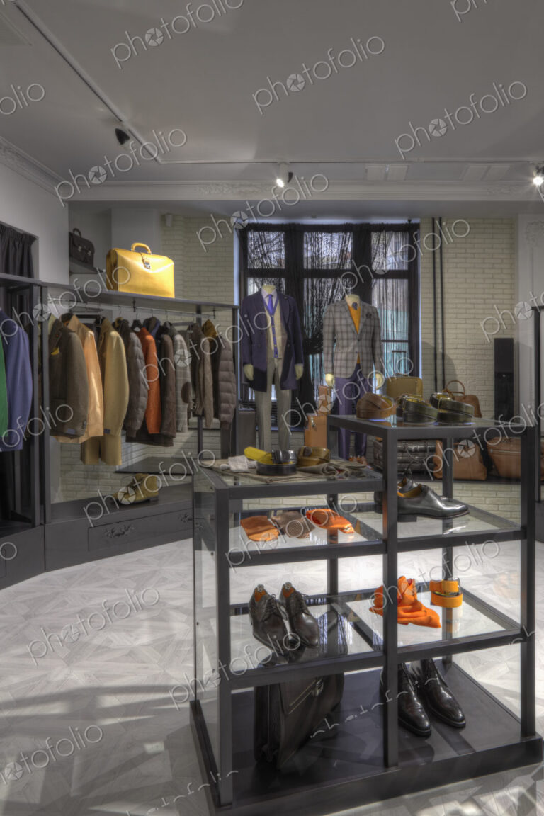 Suits and shoes on racks in clothing store for men