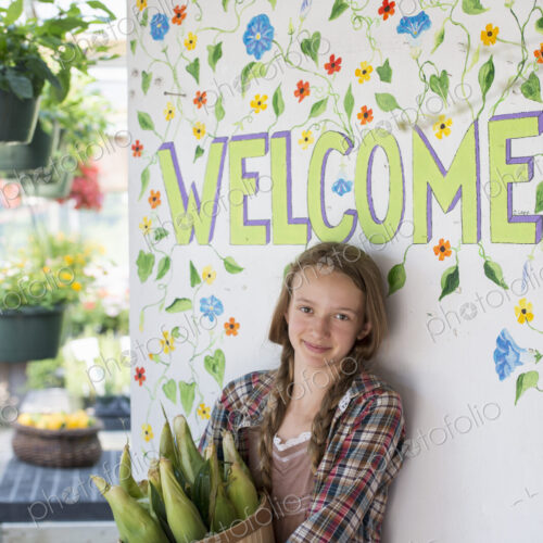 Summer on an organic farm. A girl holding a basket of fresh corn standing by the… Summer on an organic farm. A girl holding a basket of fresh corn standing by the…