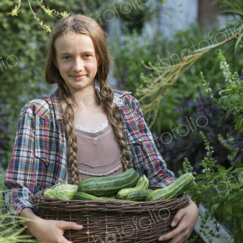 Summer on an organic farm. A girl holding a basket of fresh marrows. Summer on an organic farm. A girl holding a basket of fresh marrows.