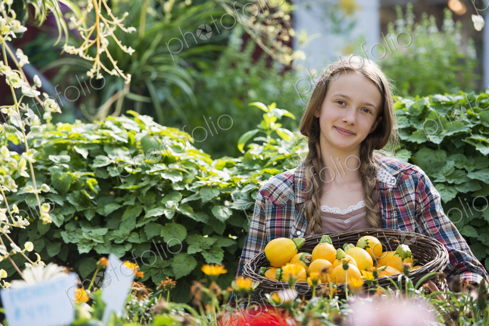 Summer on an organic farm. A girl holding a basket of fresh squash vegetables.