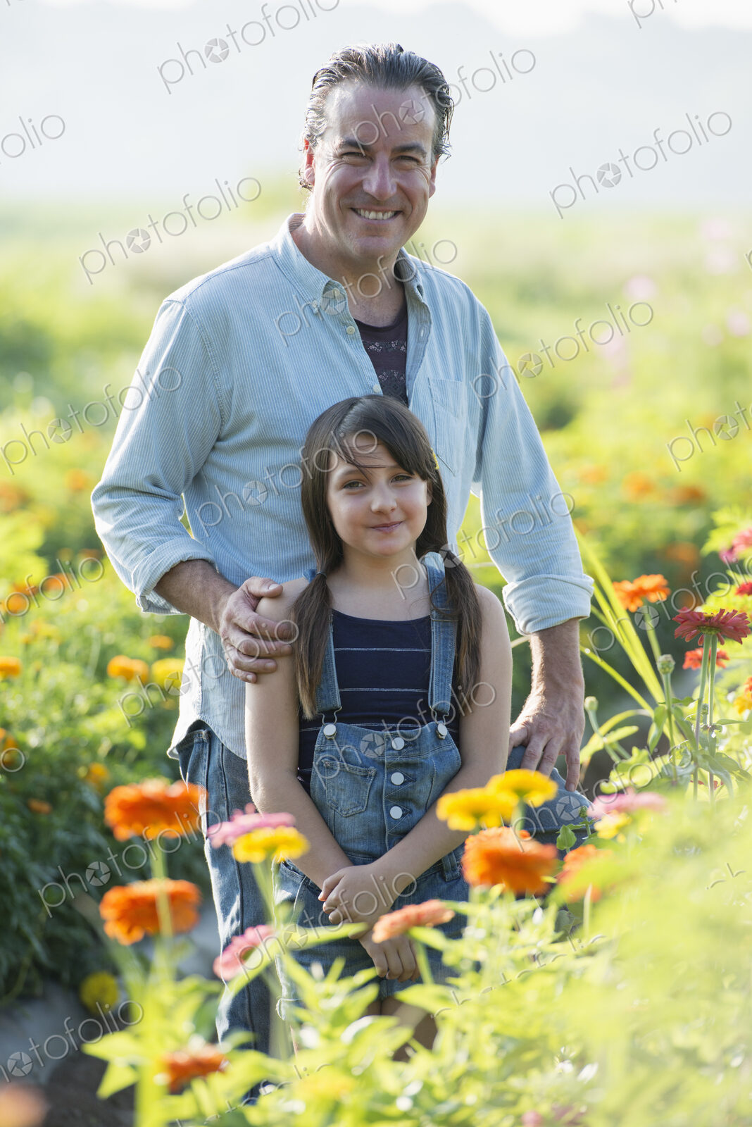 Summer on an organic farm. A man and a girl in a field of flowers.