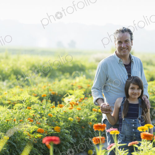 Summer on an organic farm. A man and a girl in a field of flowers. Summer on an organic farm. A man and a girl in a field of flowers.