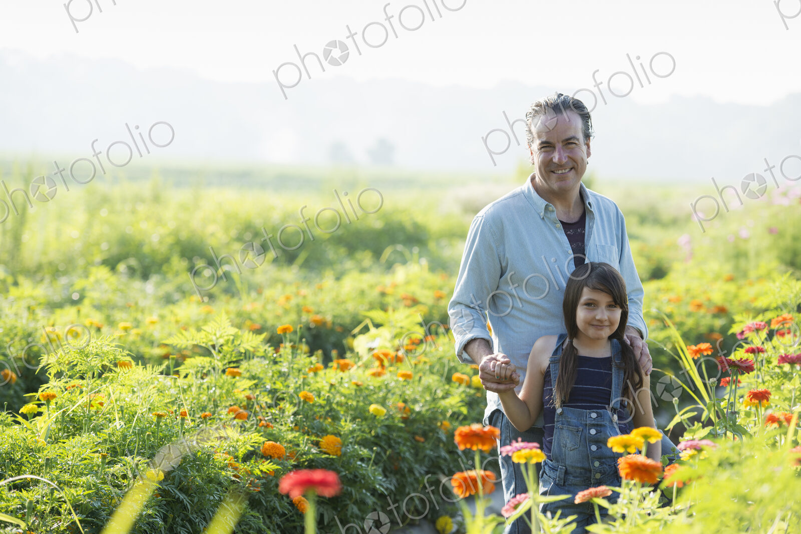 Summer on an organic farm. A man and a girl in a field of flowers.