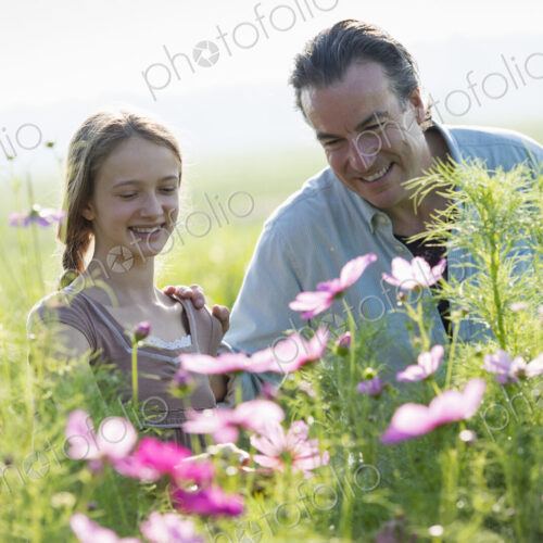 Summer on an organic farm. A man and a girl in a field of flowers. Summer on an organic farm. A man and a girl in a field of flowers.