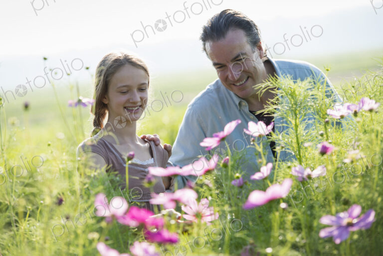 Summer on an organic farm. A man and a girl in a field of flowers.