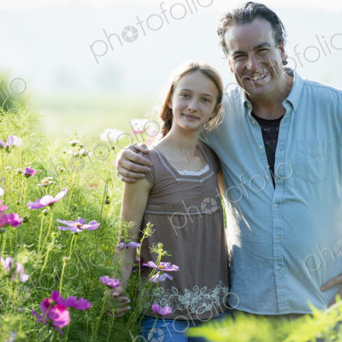 Summer on an organic farm. A man and a girl in a field of flowers. Summer on an organic farm. A man and a girl in a field of flowers.