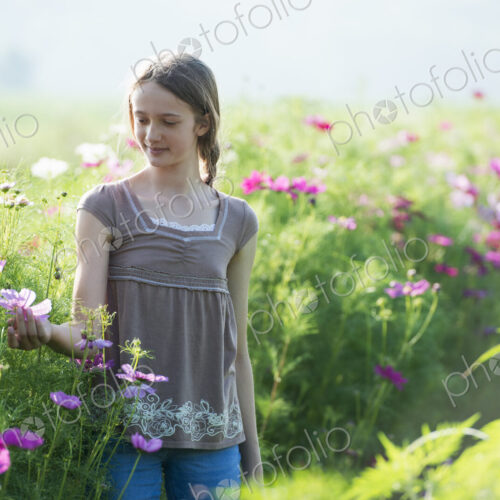 Summer on an organic farm. A young girl in a field of flowers.