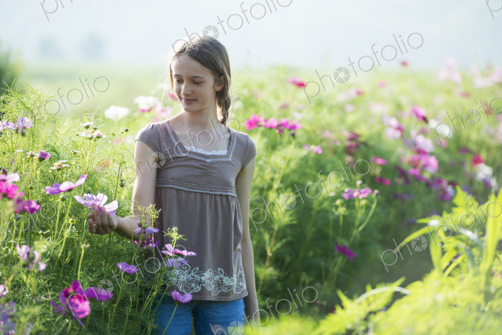Summer on an organic farm. A young girl in a field of flowers.