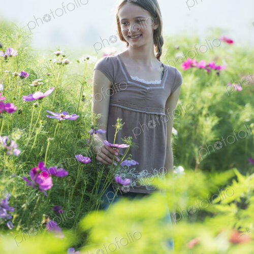 Summer on an organic farm. A young girl in a field of flowers.