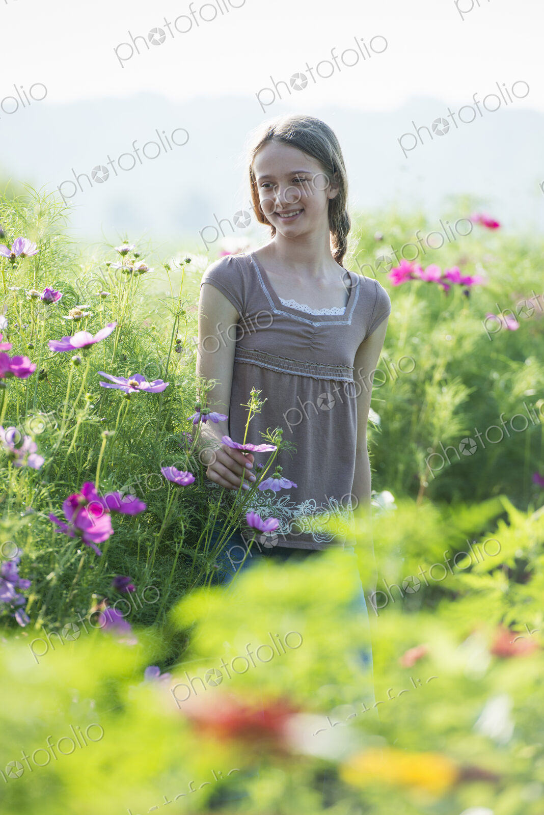Summer on an organic farm. A young girl in a field of flowers.