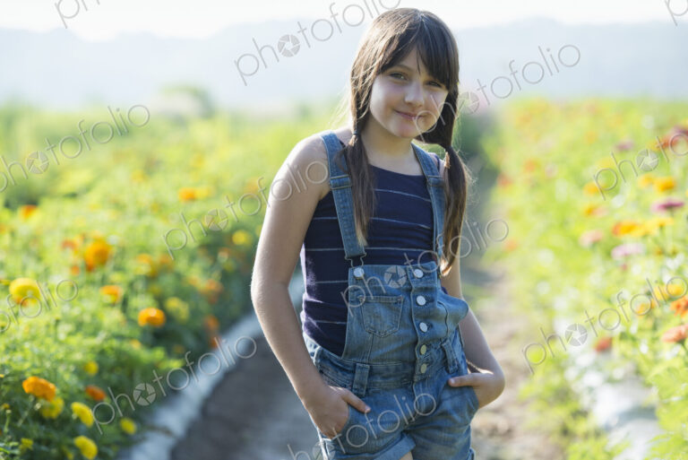 Summer on an organic farm. A young girl in a field of flowers.