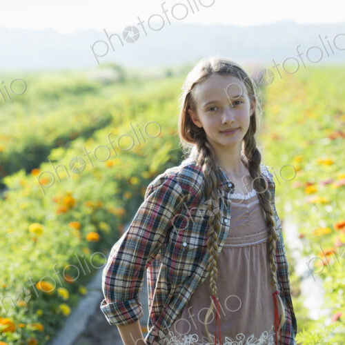 Summer on an organic farm. A young girl in a field of flowers.