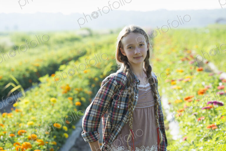 Summer on an organic farm. A young girl in a field of flowers.