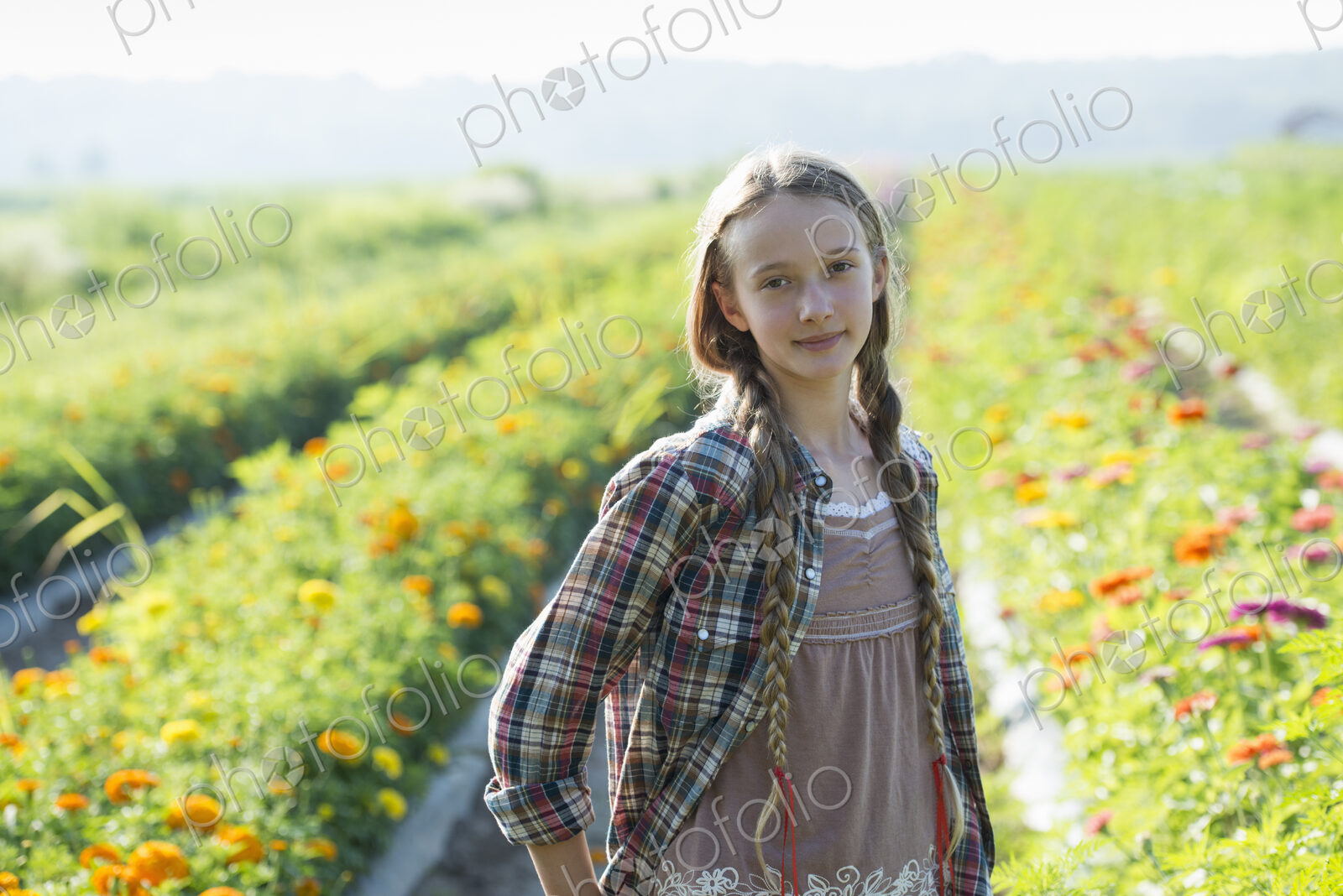 Summer on an organic farm. A young girl in a field of flowers.