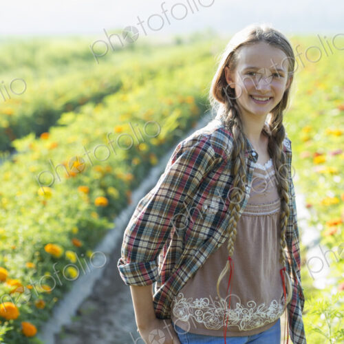 Summer on an organic farm. A young girl in a field of flowers.