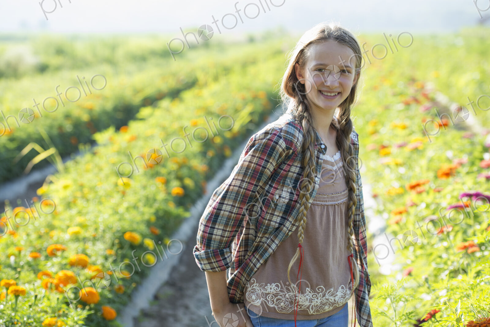 Summer on an organic farm. A young girl in a field of flowers.