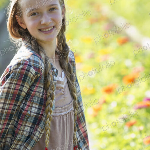 Summer on an organic farm. A young girl in a field of flowers.