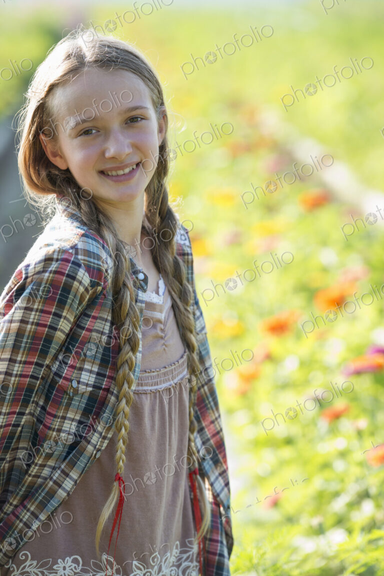 Summer on an organic farm. A young girl in a field of flowers.