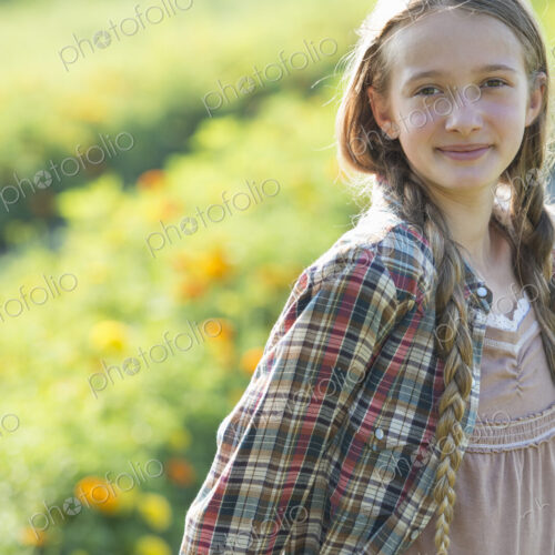 Summer on an organic farm. A young girl in a field of flowers.