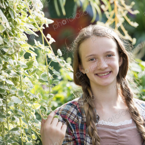 Summer on an organic farm. A young girl in a plant nursery full of flowers. Summer on an organic farm. A young girl in a plant nursery full of flowers.