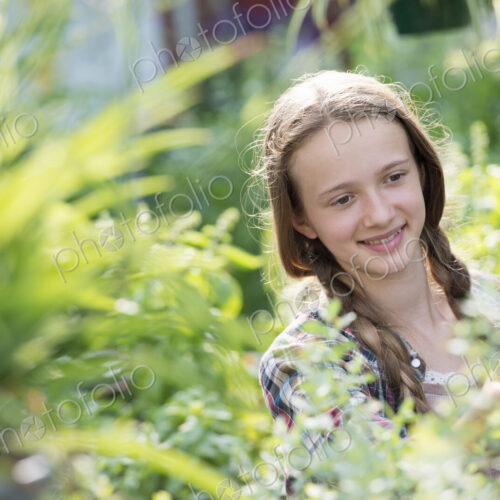 Summer on an organic farm. A young girl in a plant nursery full of flowers. Summer on an organic farm. A young girl in a plant nursery full of flowers.