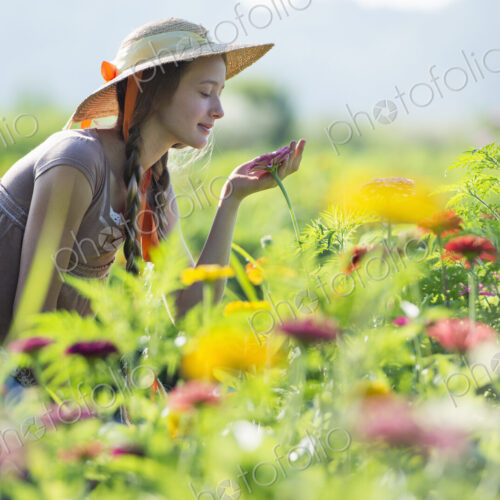 Summer on an organic farm. A young woman in a field of flowers.
