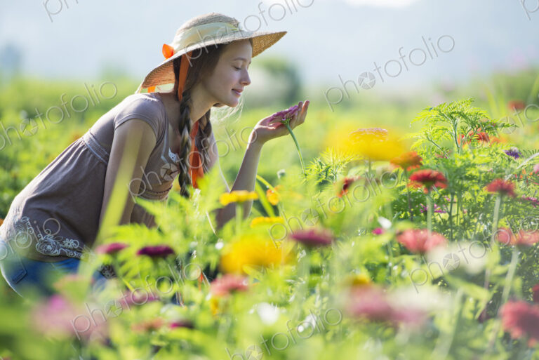Summer on an organic farm. A young woman in a field of flowers.