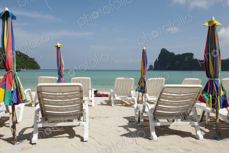 Sun loungers and umbrellas on a beach in the Andaman islands off the coast of Thailand.