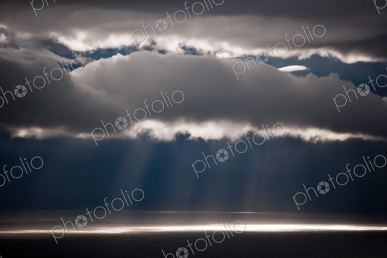 Sun rays stream down thru clouds, Kamai National Park, Alaska, USA