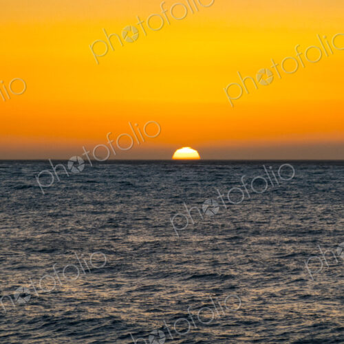Sun setting on horizon above the Strait of Juan de Fuca, Port Angeles, Wa USA