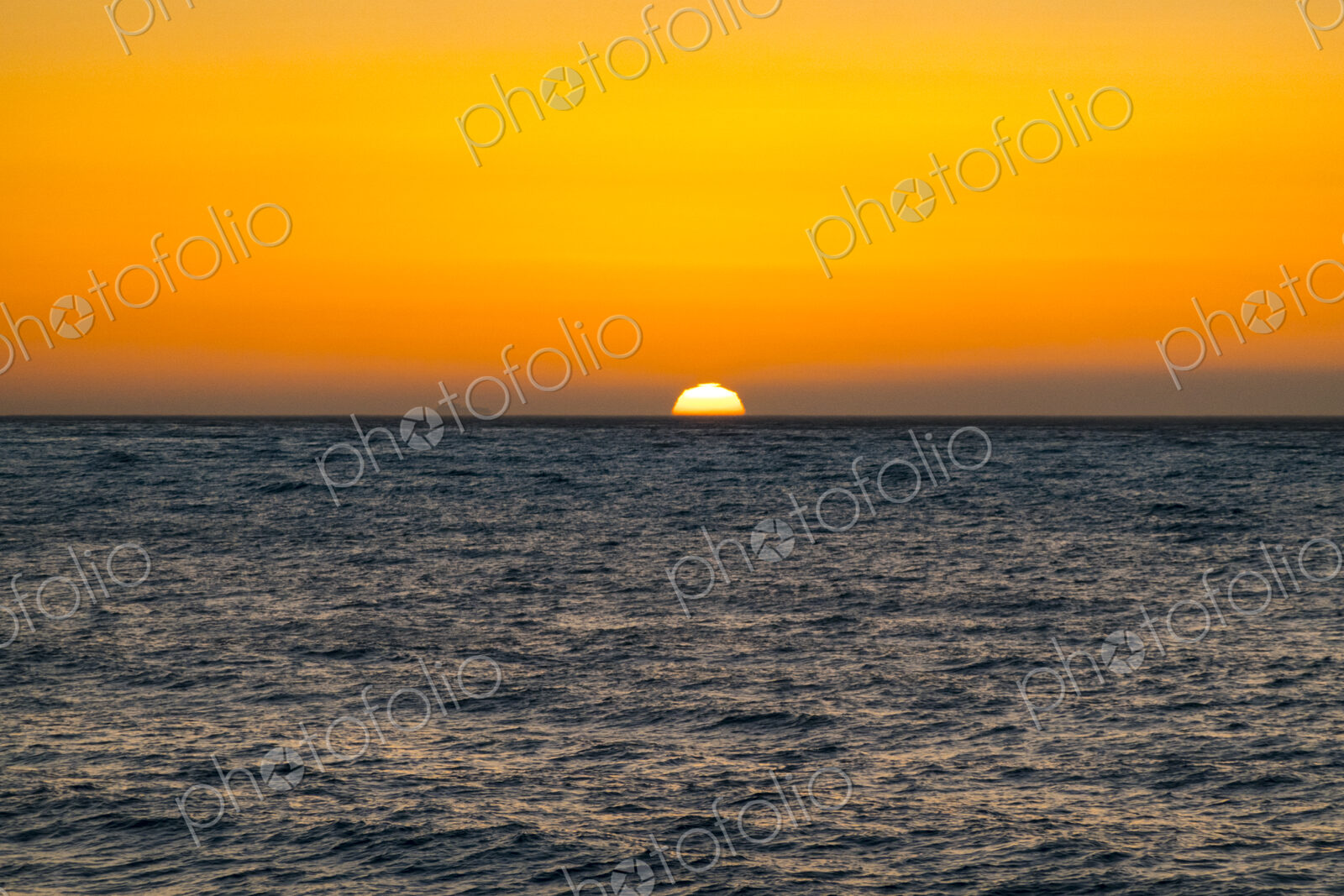 Sun setting on horizon above the Strait of Juan de Fuca, Port Angeles, Wa USA
