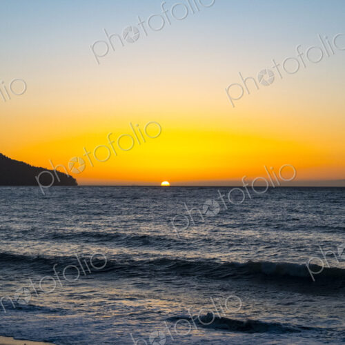 Sun setting on the horizon above the Strait of Juan de Fuca over the sea. Sun setting on the horizon above the Strait of Juan de Fuca over the sea.
