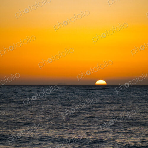 Sun setting on the horizon above the Strait of Juan de Fuca over the sea. Sun setting on the horizon above the Strait of Juan de Fuca over the sea.