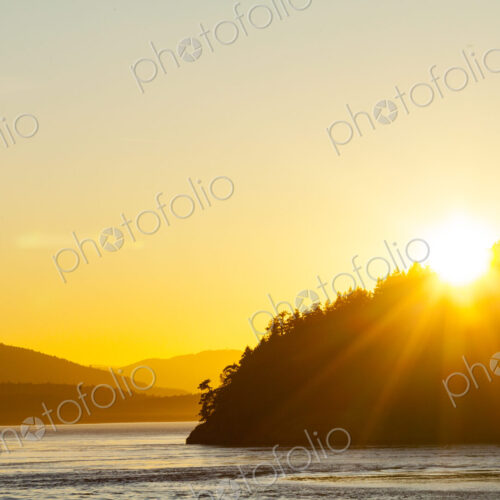 Sun setting over a headland in the Strait of Georgia, the Gulf Islands landscape.