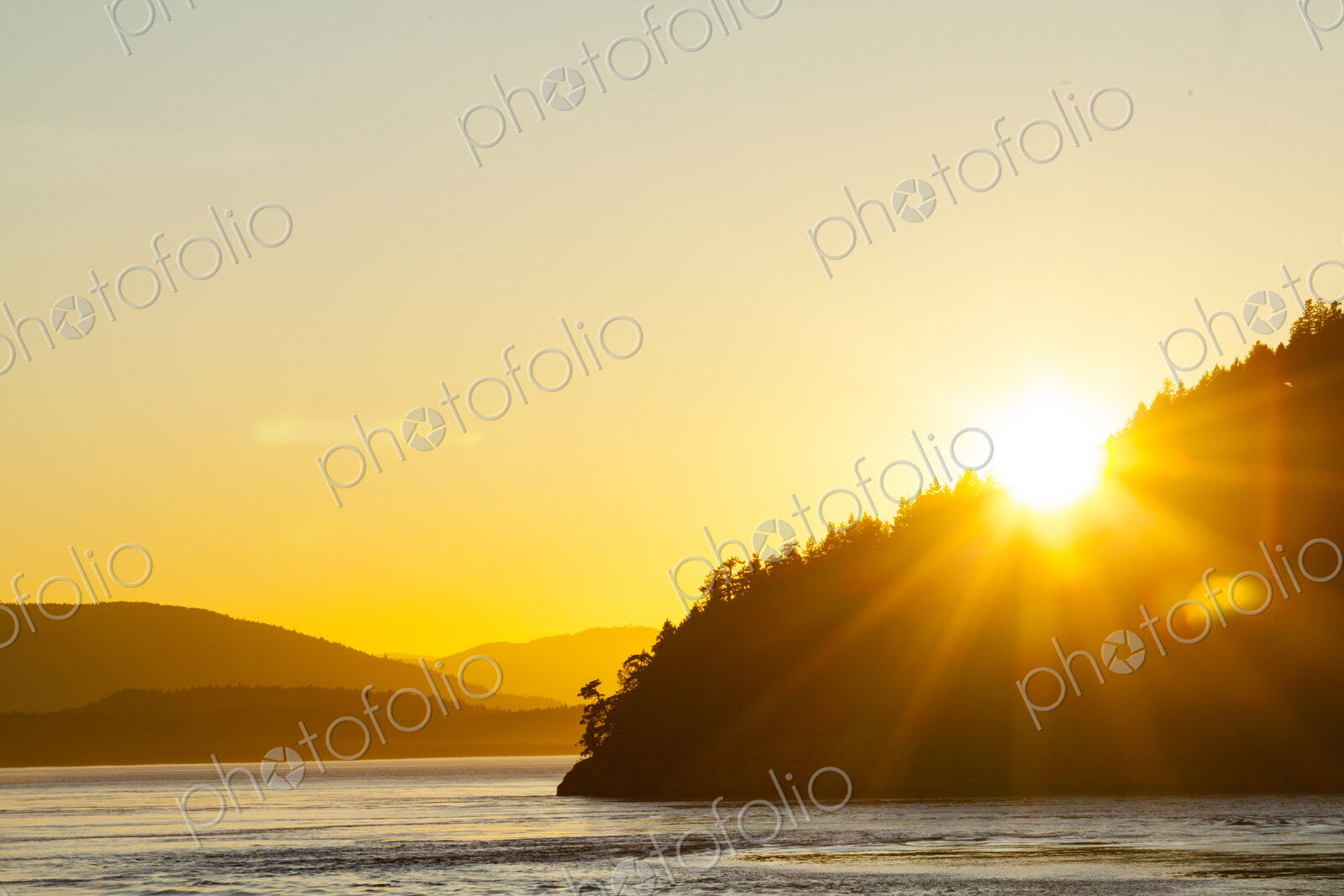 Sun setting over a headland in the Strait of Georgia, the Gulf Islands landscape.