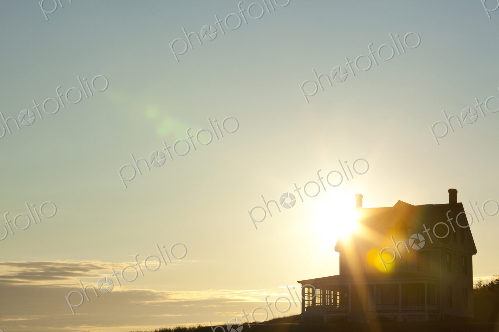 Sun shining behind rural house