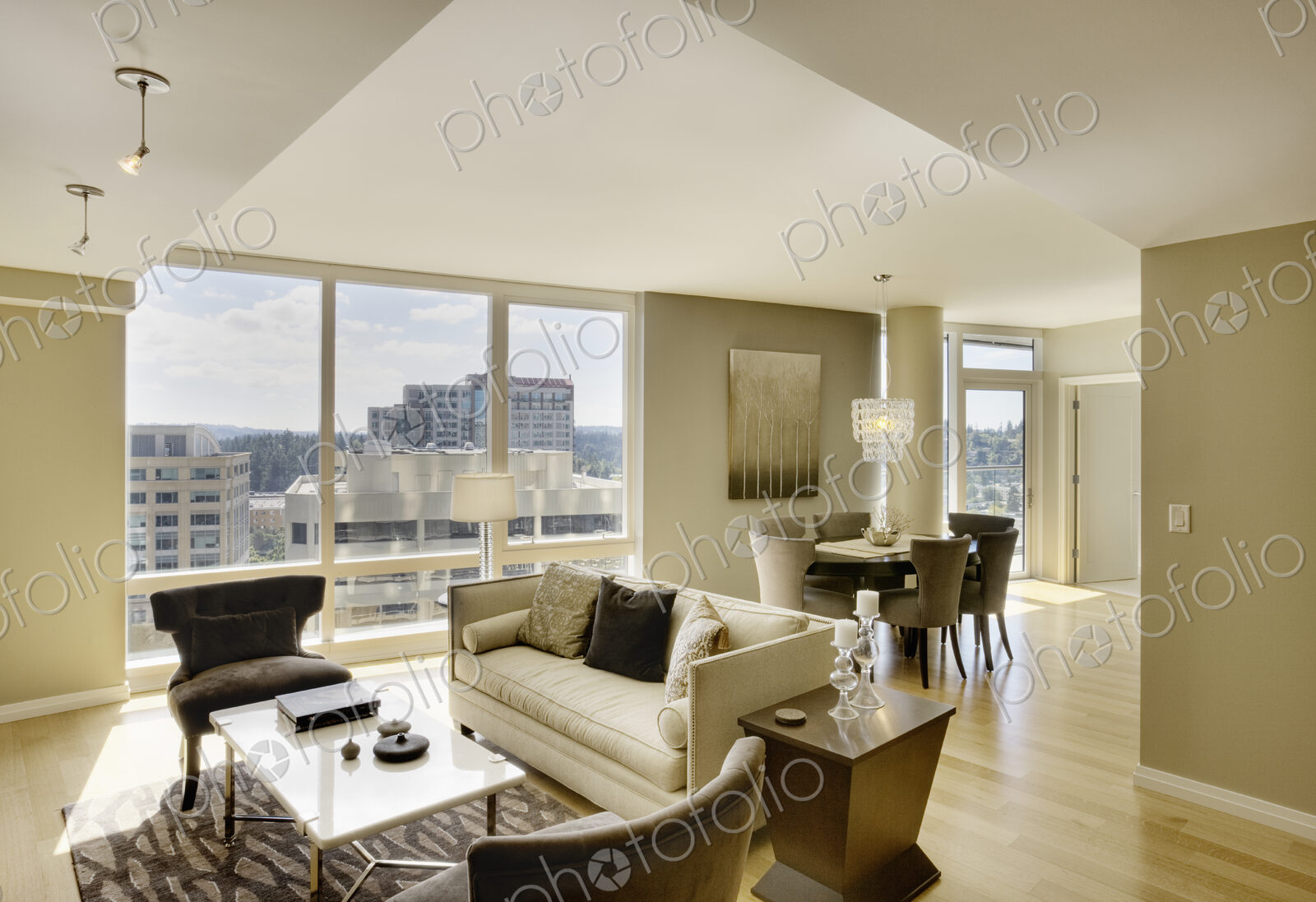 Sun shining through windows of open floor plan in luxury highrise apartment