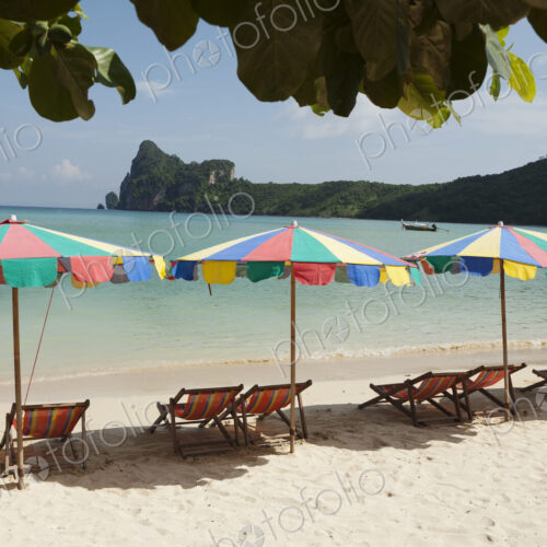 Sun umbrellas on a beach in the Andaman islands off the coast of Thailand.