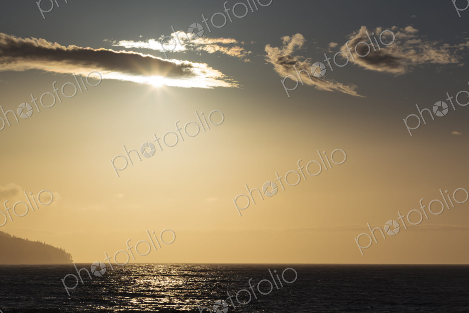 Sunlight over the Strait of Juan de Fuca, lighting up the clouds passing across the sun.