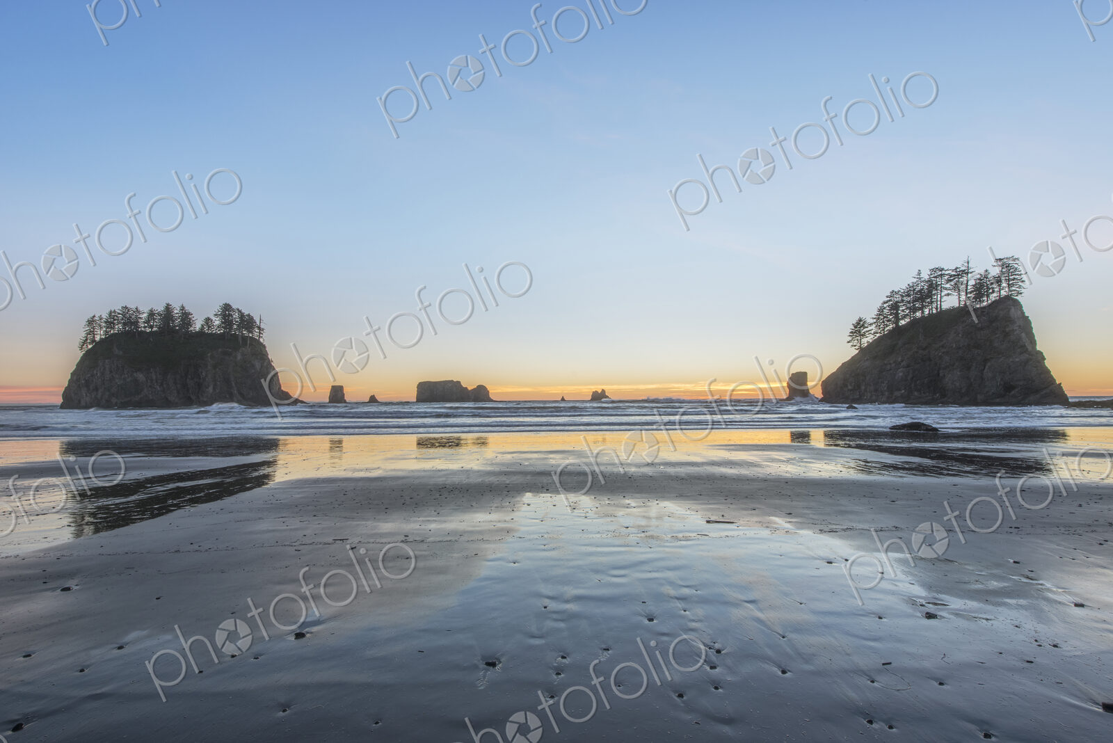 Sunrise horizon behind rock formations on beach