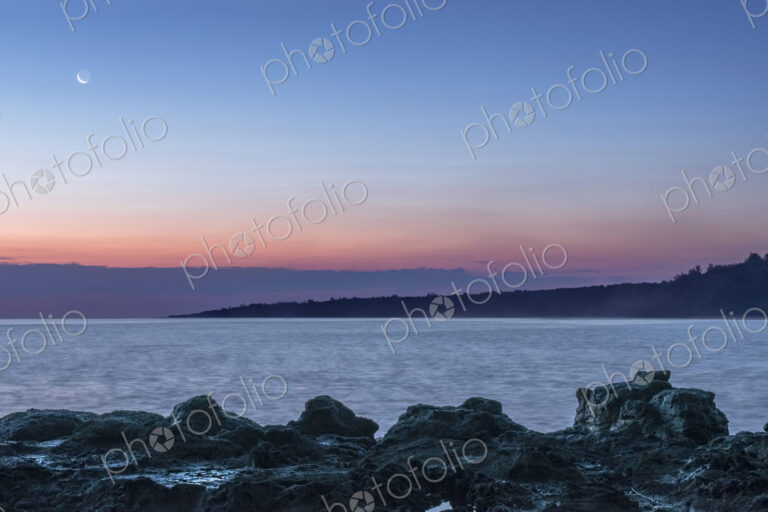 Sunrise over rock formations on beach