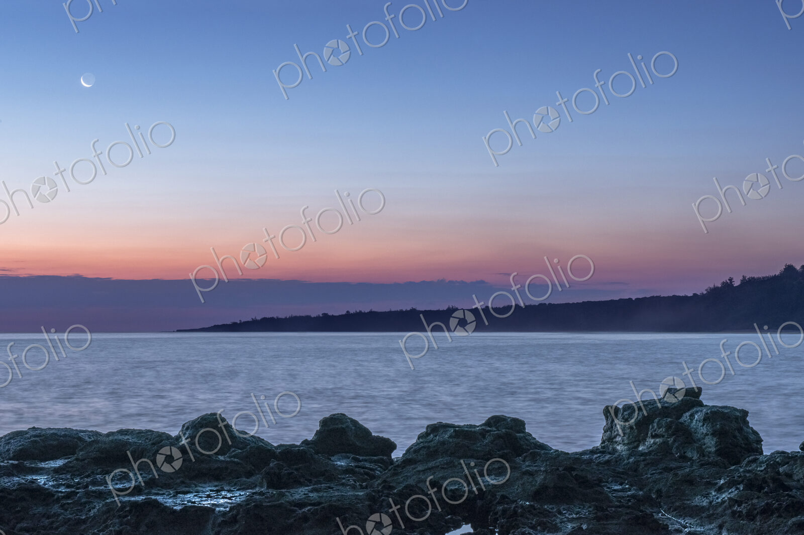 Sunrise over rock formations on beach