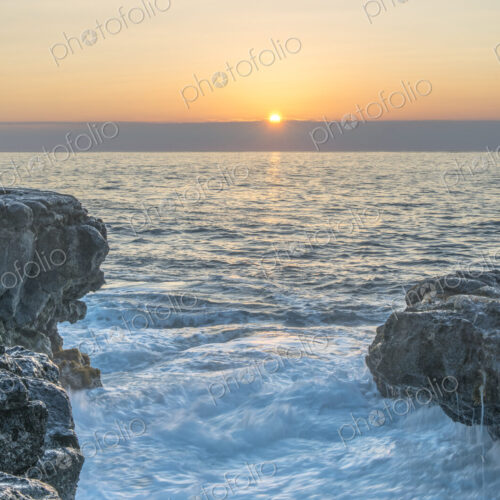 Sunrise over rock formations on beach