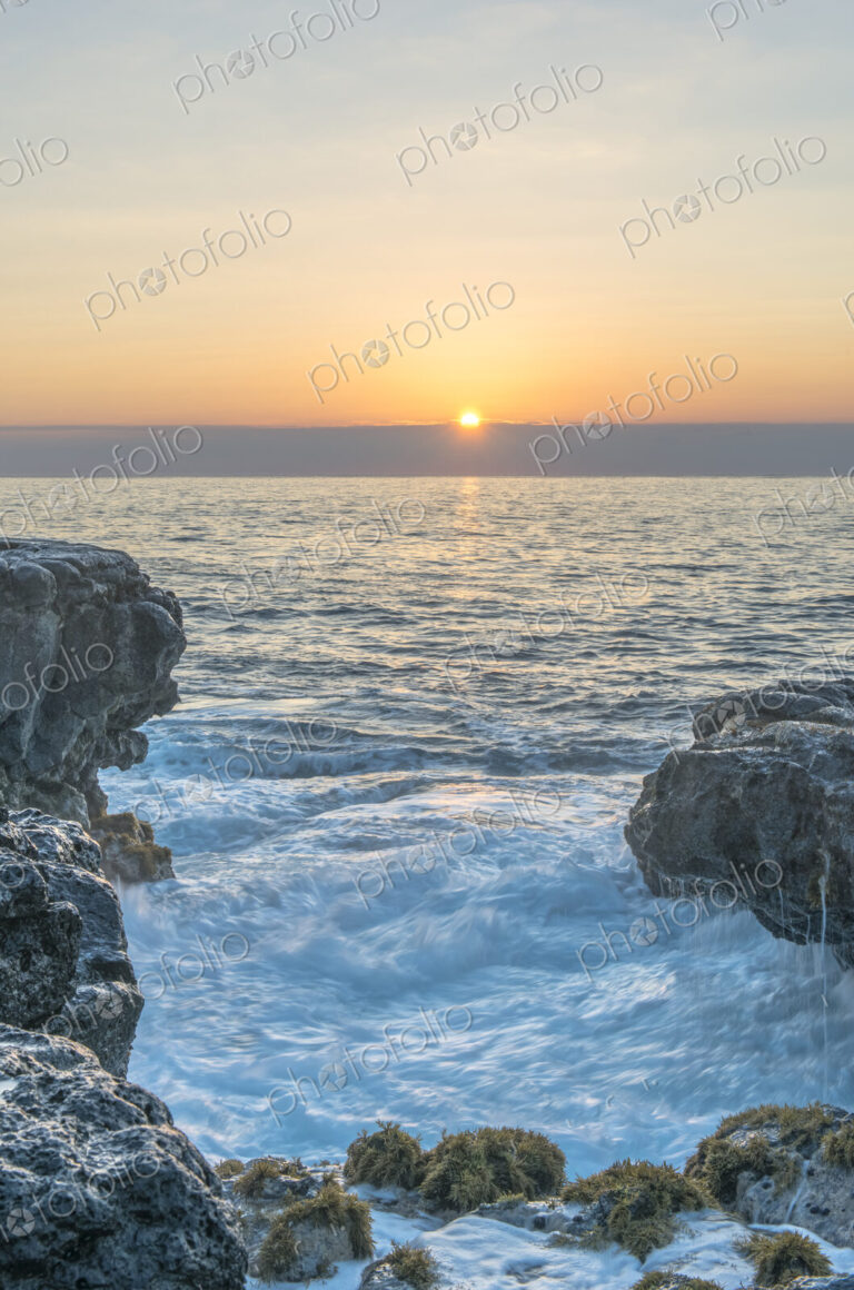 Sunrise over rock formations on beach