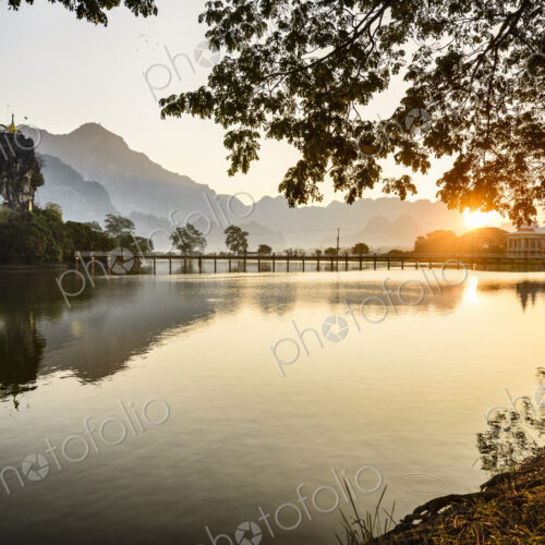 Sunrise over the lake at Hpa An, a footbridge, shrine and mountain landscape. Sunrise over the lake at Hpa An, a footbridge, shrine and mountain landscape.
