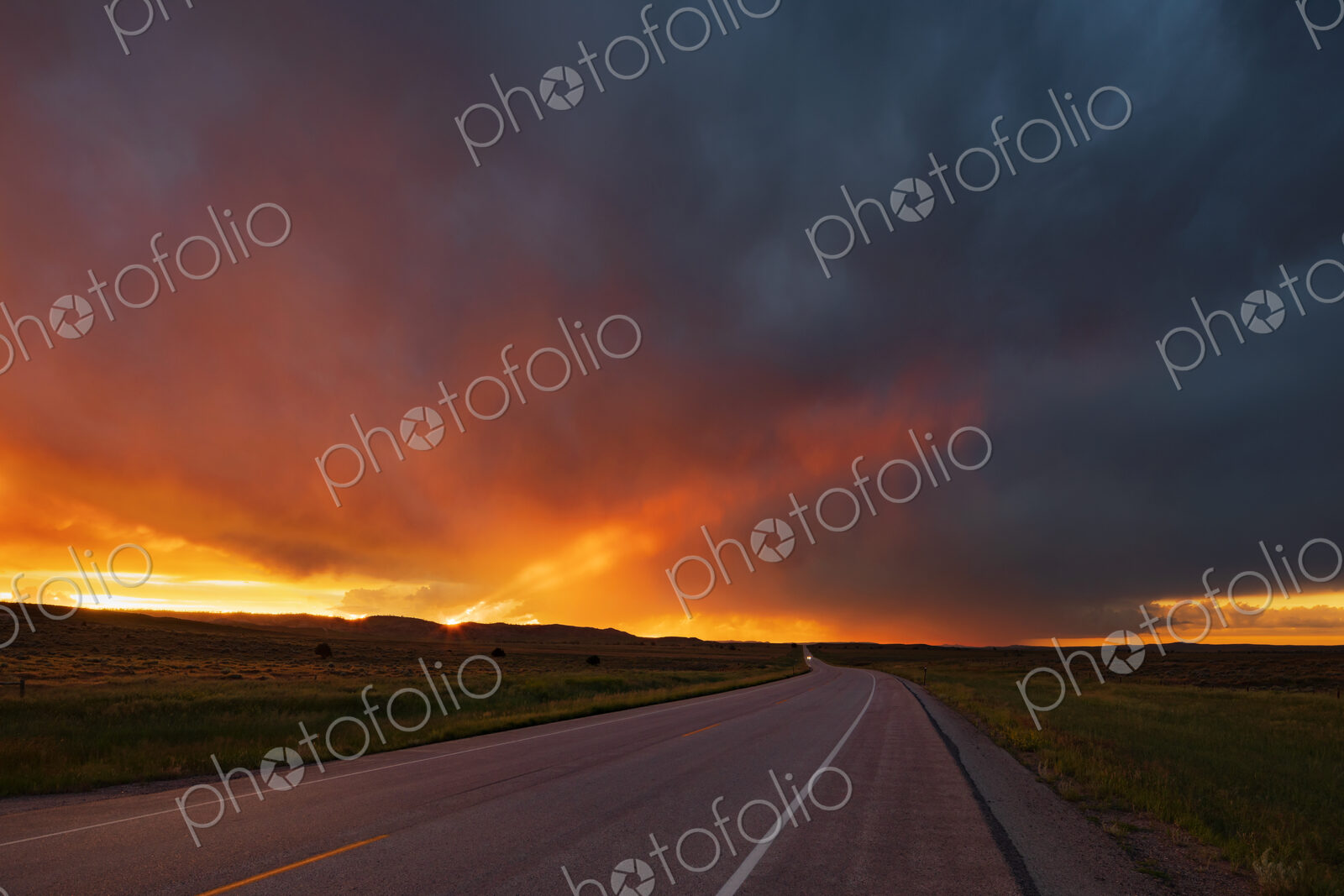 Sunset on WY Highway 59, the glow of the setting sun on the horizon, and storm clouds…