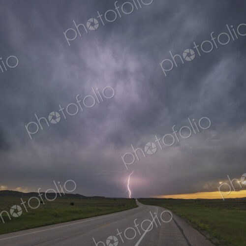 Sunset on WY Highway 59, view of the road ahead with cloud to ground lightning and… Sunset on WY Highway 59, view of the road ahead with cloud to ground lightning and…
