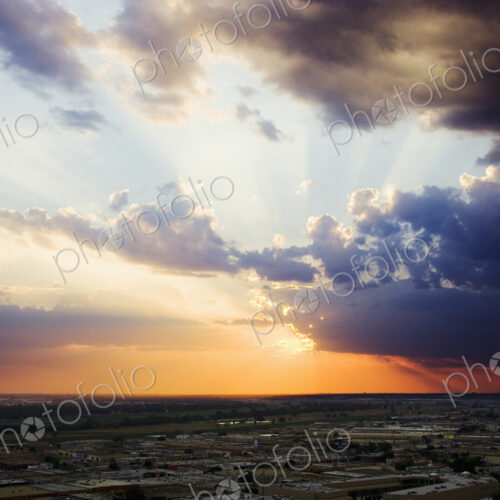 Sunset on the horizon, view over the roofs of light industrial buildings.